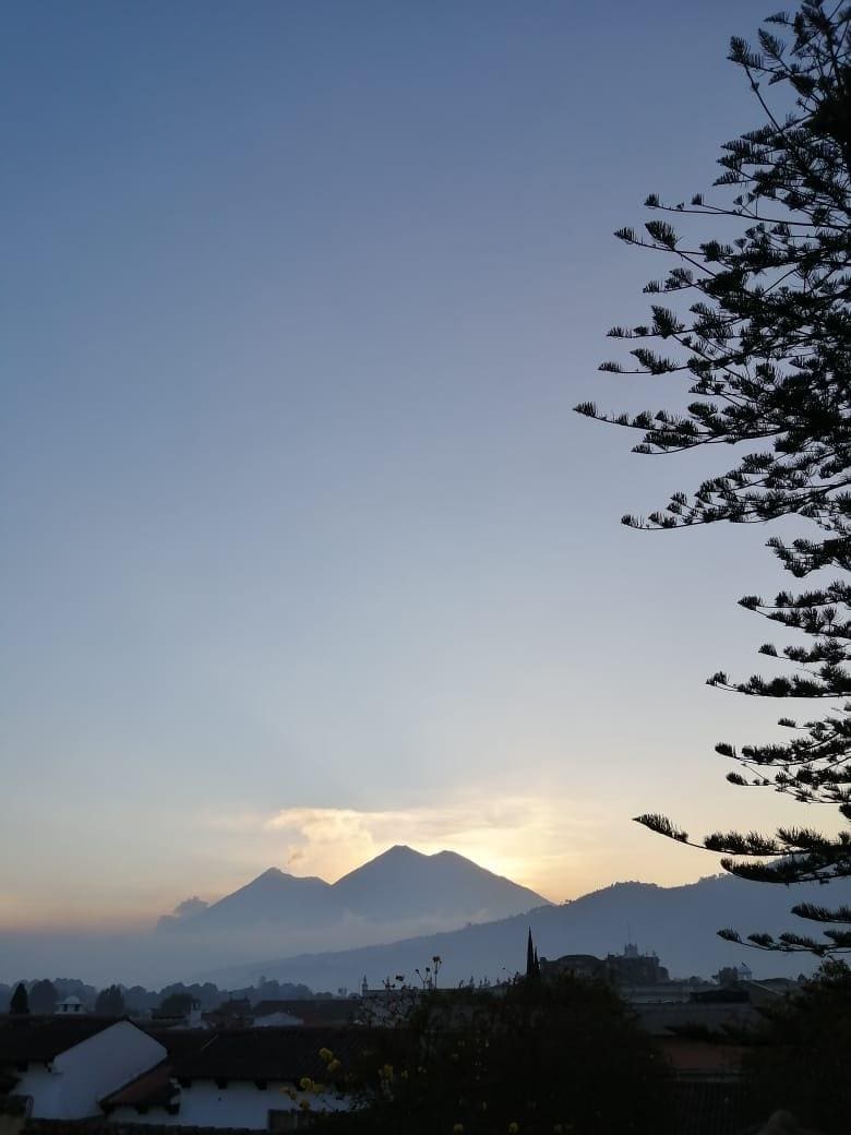 Vista del atardecer detrás de los volcanes desde la terraza de Adra Hostel.