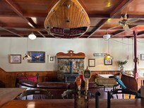 Spotless lounge/bar/dining area with a classic wood burning stove.