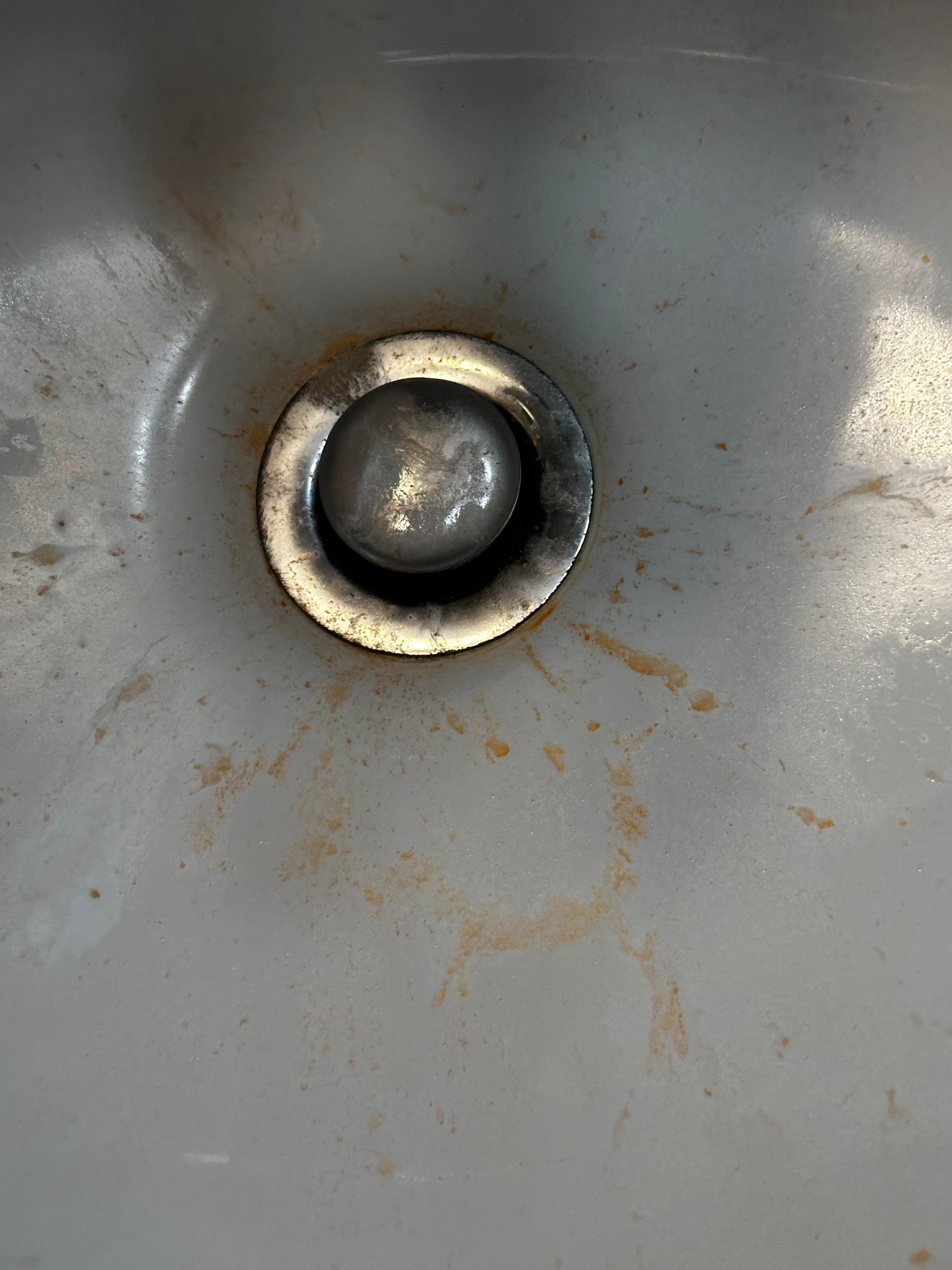 Orange splattered liquid dried in sink