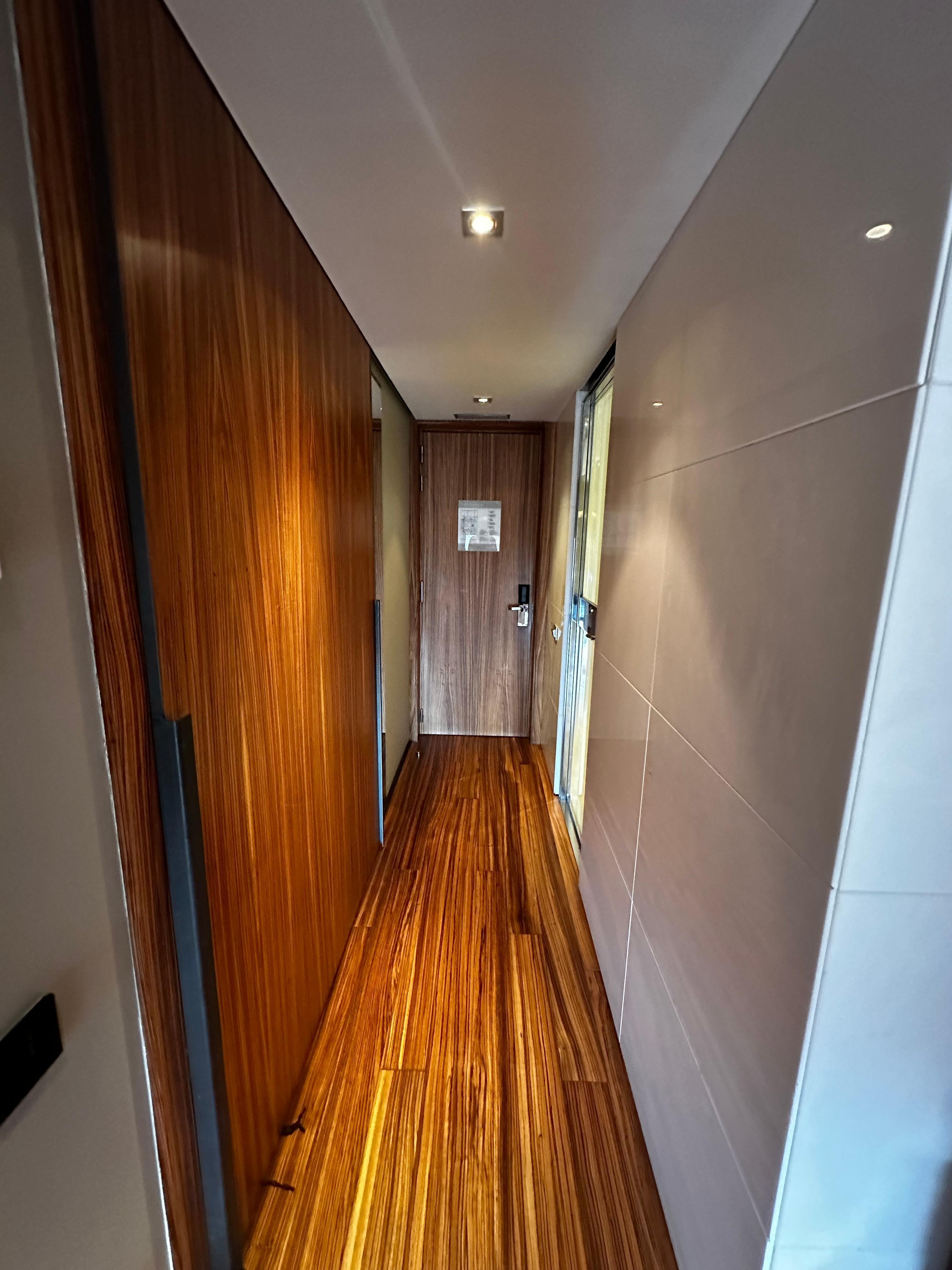 Corredor no quarto. Banheiro a direita. A esquerda, armário. Espaço bem projetado.
