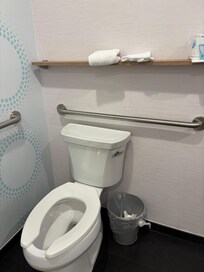 Clean towels stacked above toilet,without lid to prevent spray during flushing.