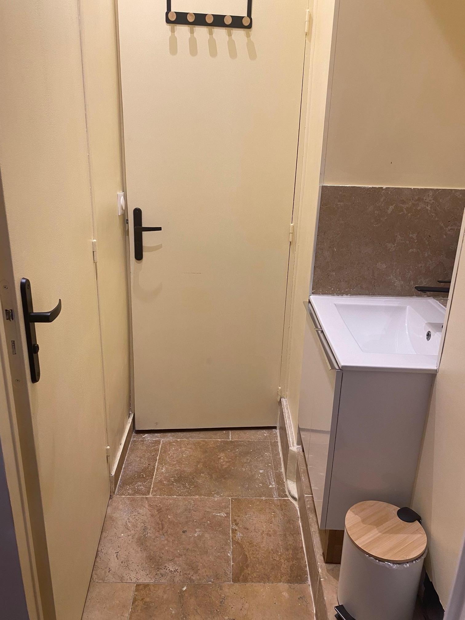 Washbasin opposite toilet, just beside kitchen/living room