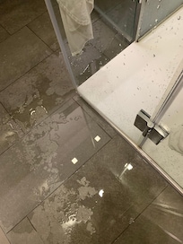 Puddles of water on the floor after a shower