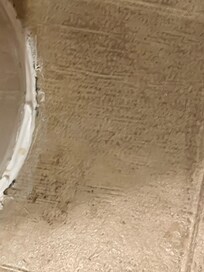 Stain at the base of the toilet. (From of toilet)