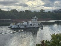 Several tugboats moving barges up and down the river.