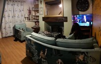 Lounge, with 2 seater sofa and 1 chair, and tv.
