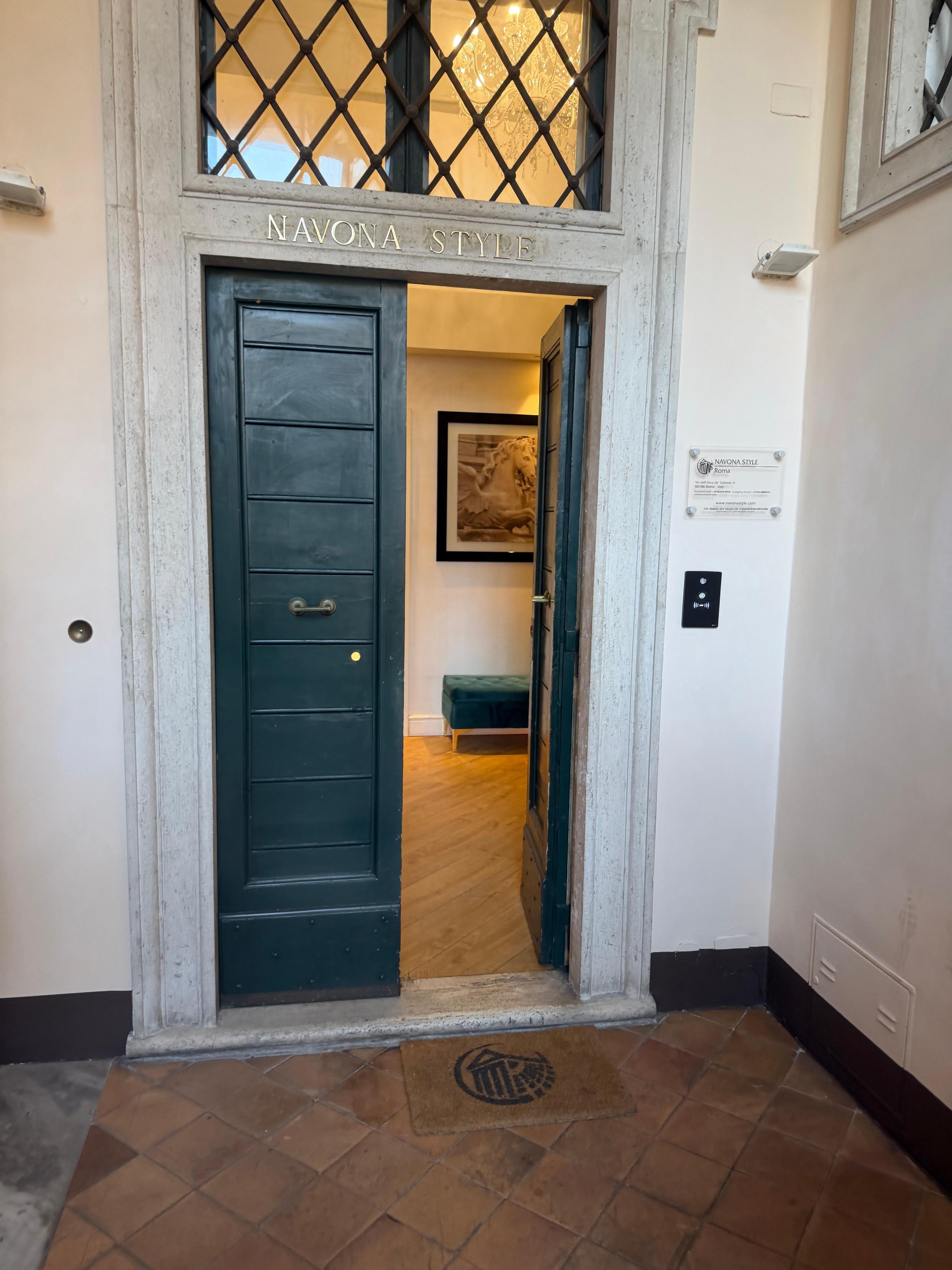 Up the stairs or tiny elevator/lift to 2nd big green door