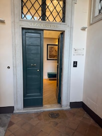 Up the stairs or tiny elevator/lift to 2nd big green door