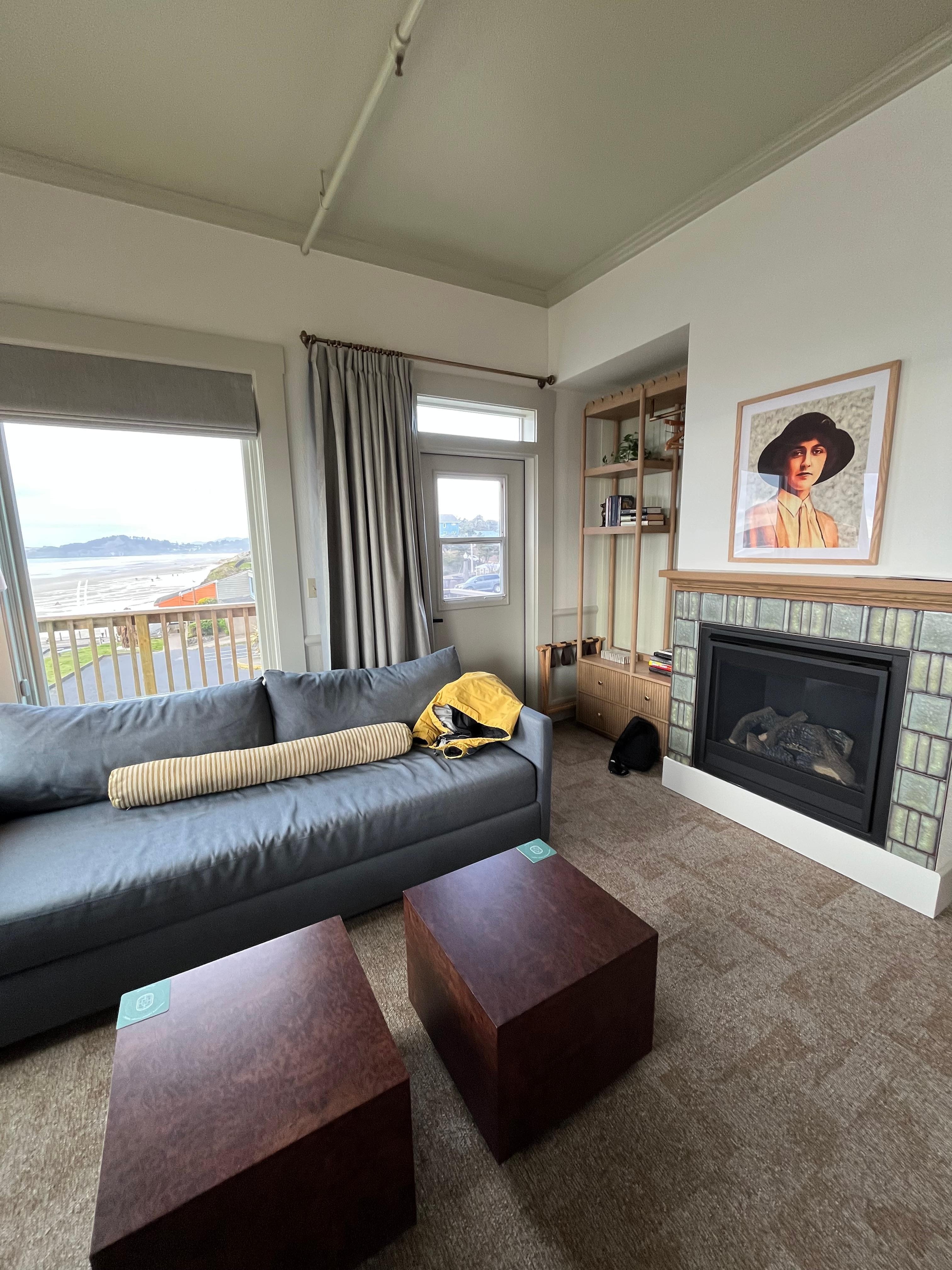 The main room showing the windows, couch, fireplace, and tables 