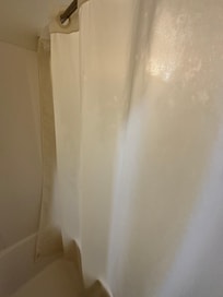 Inside of the shower curtain with pink toiletries squirted on it. The hotel doesn’t have pink anything.