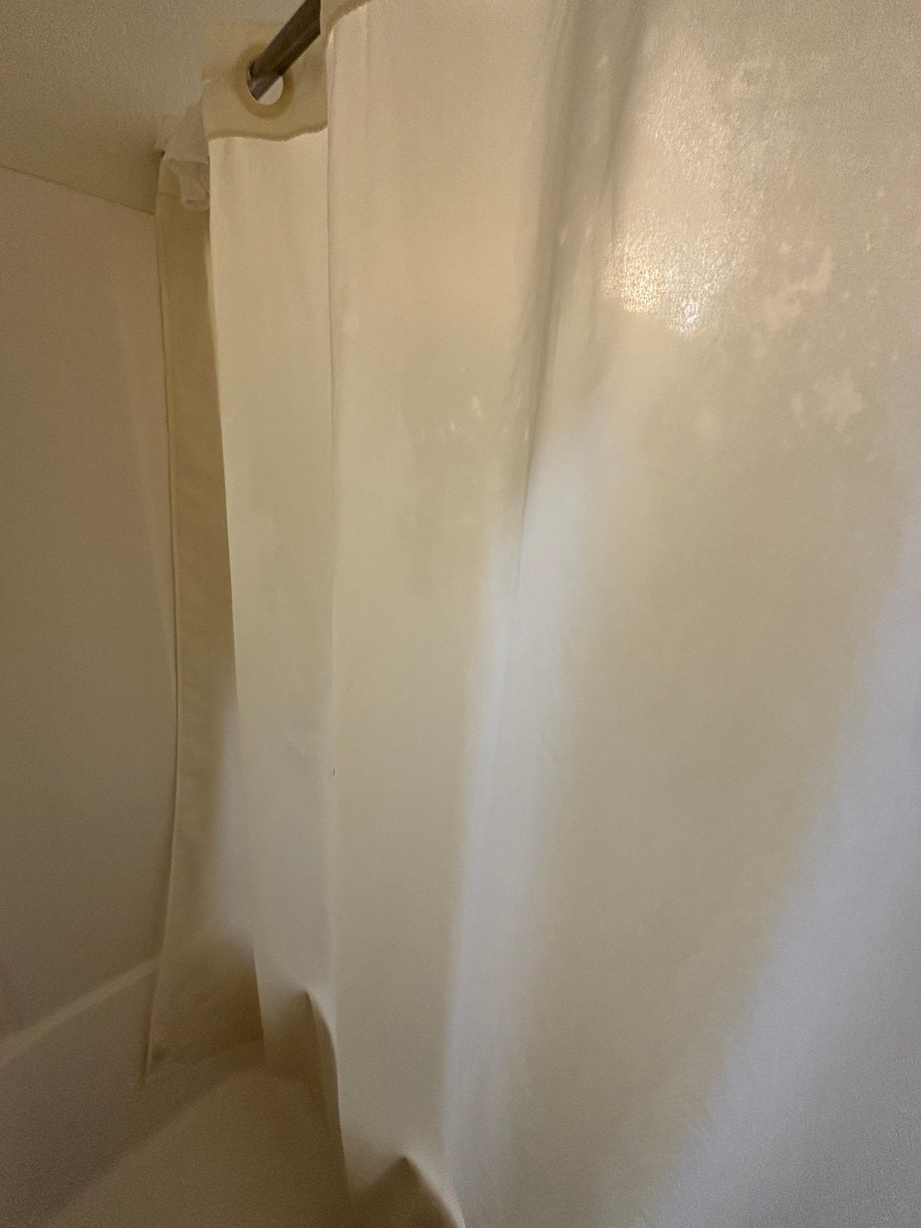 Inside of the shower curtain with pink toiletries squirted on it. The hotel doesn’t have pink anything.
