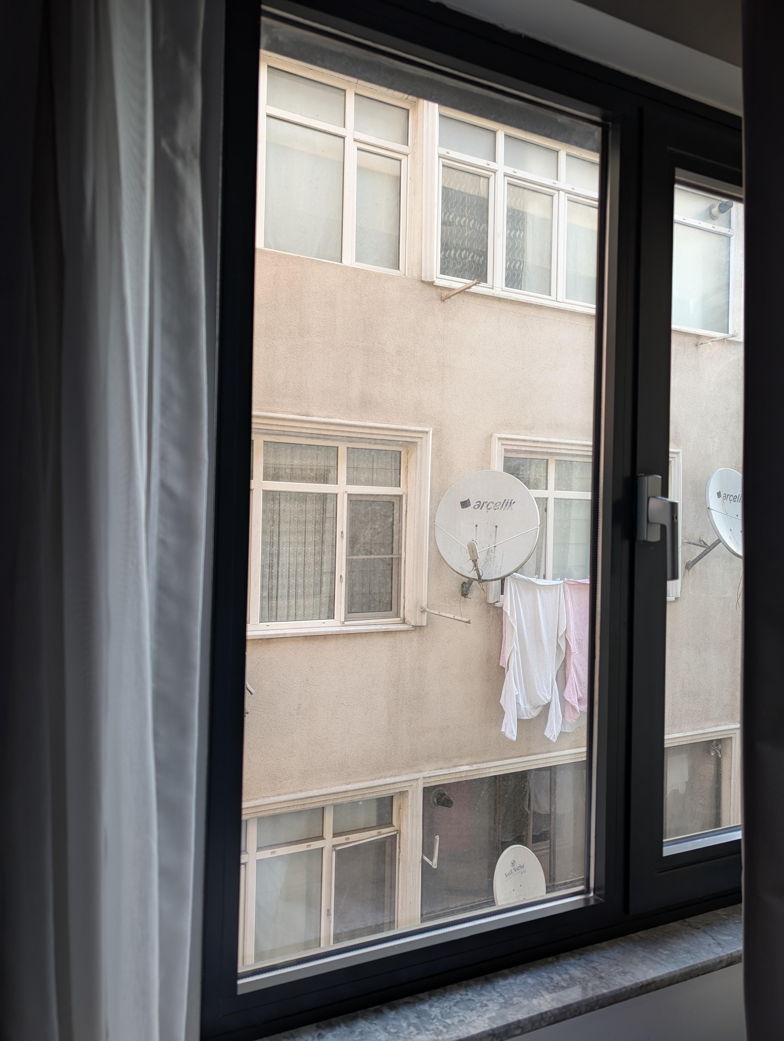 If you're familiar with Şirinevler, you know it's not a tourist destination—and neither is this hotel. This is the view from the room, and yes, that's laundry and satellite dishes on a worn facade.