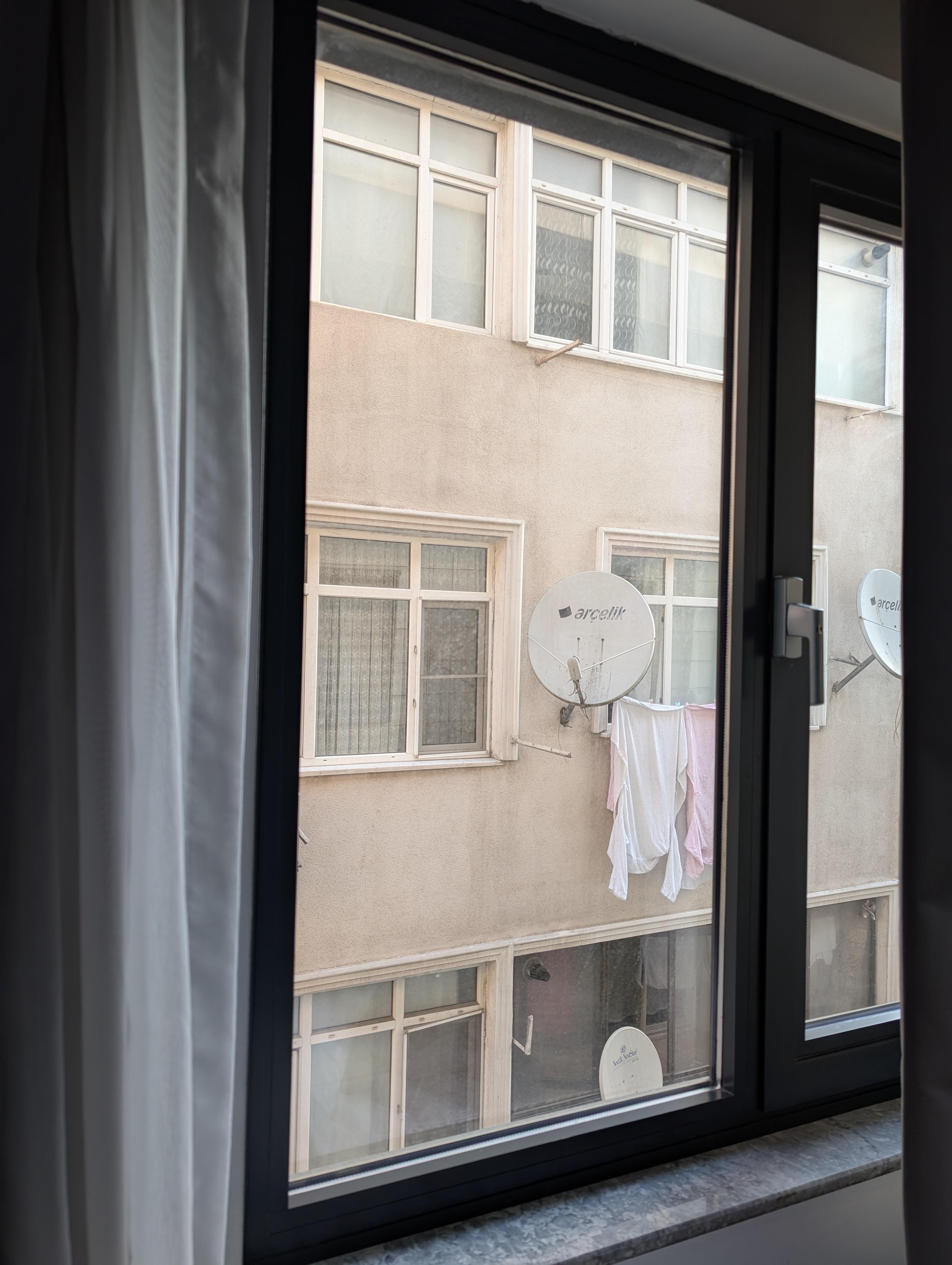 If you're familiar with Şirinevler, you know it's not a tourist destination—and neither is this hotel. This is the view from the room, and yes, that's laundry and satellite dishes on a worn facade.