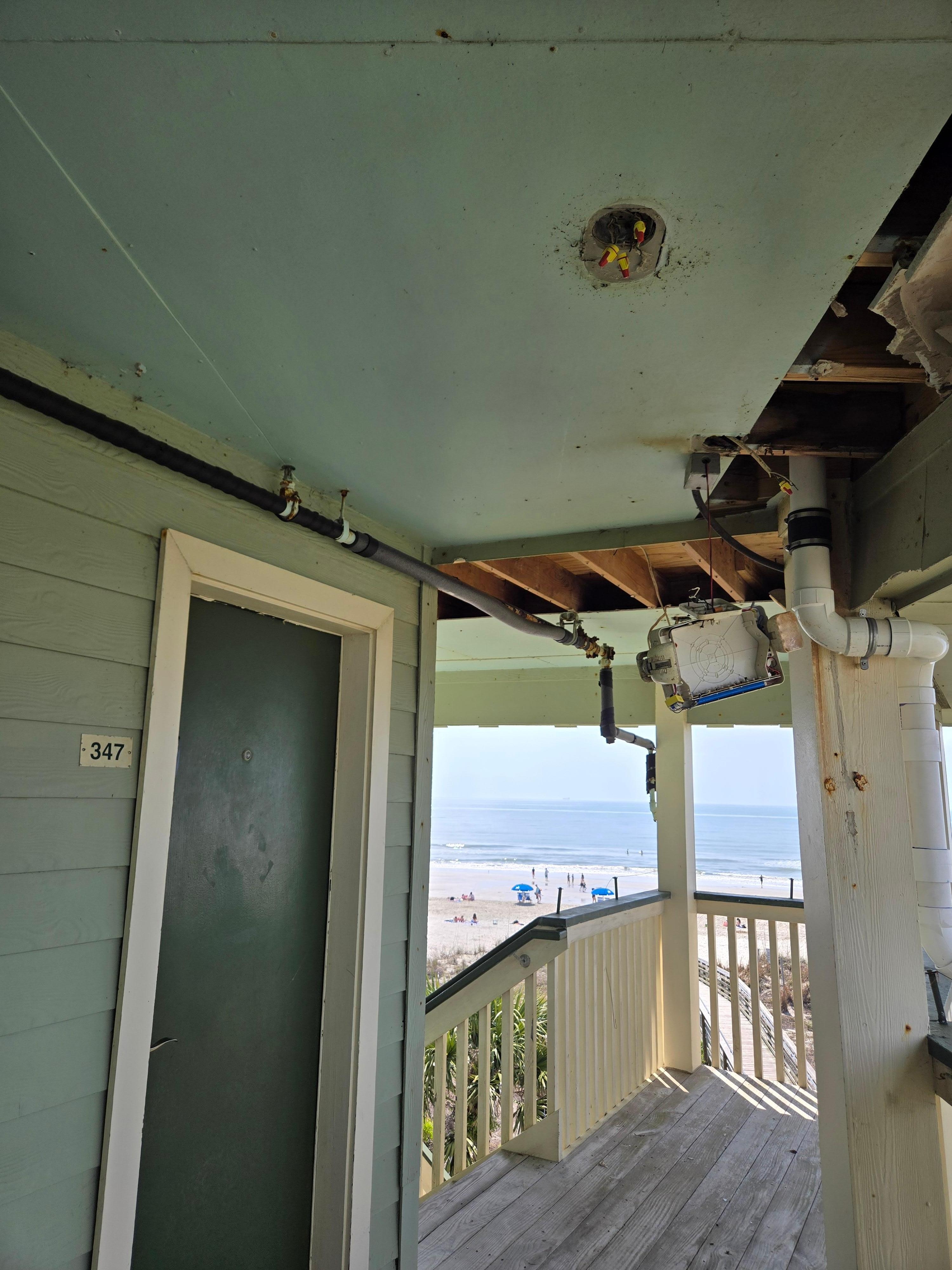 Front door. Exit sign hanging by wires.  