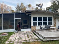 Facing back of house with deck and screened in patio.