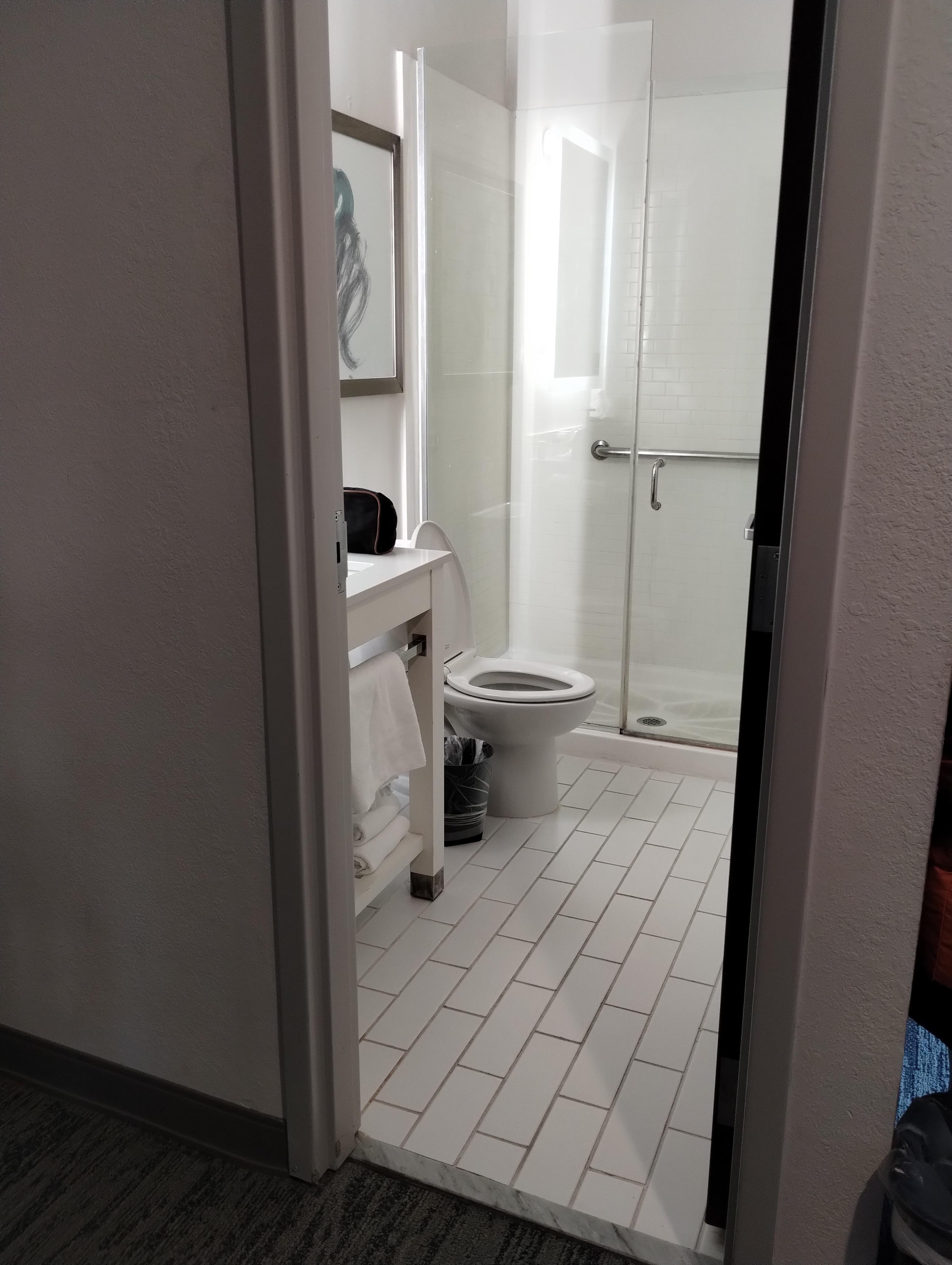 The grout in the flooring should be white.  It's white up against the wall behind the toilet and next to sink. 