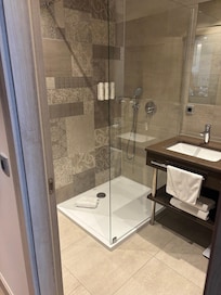 Badrummet med en dusch och ett badkar.