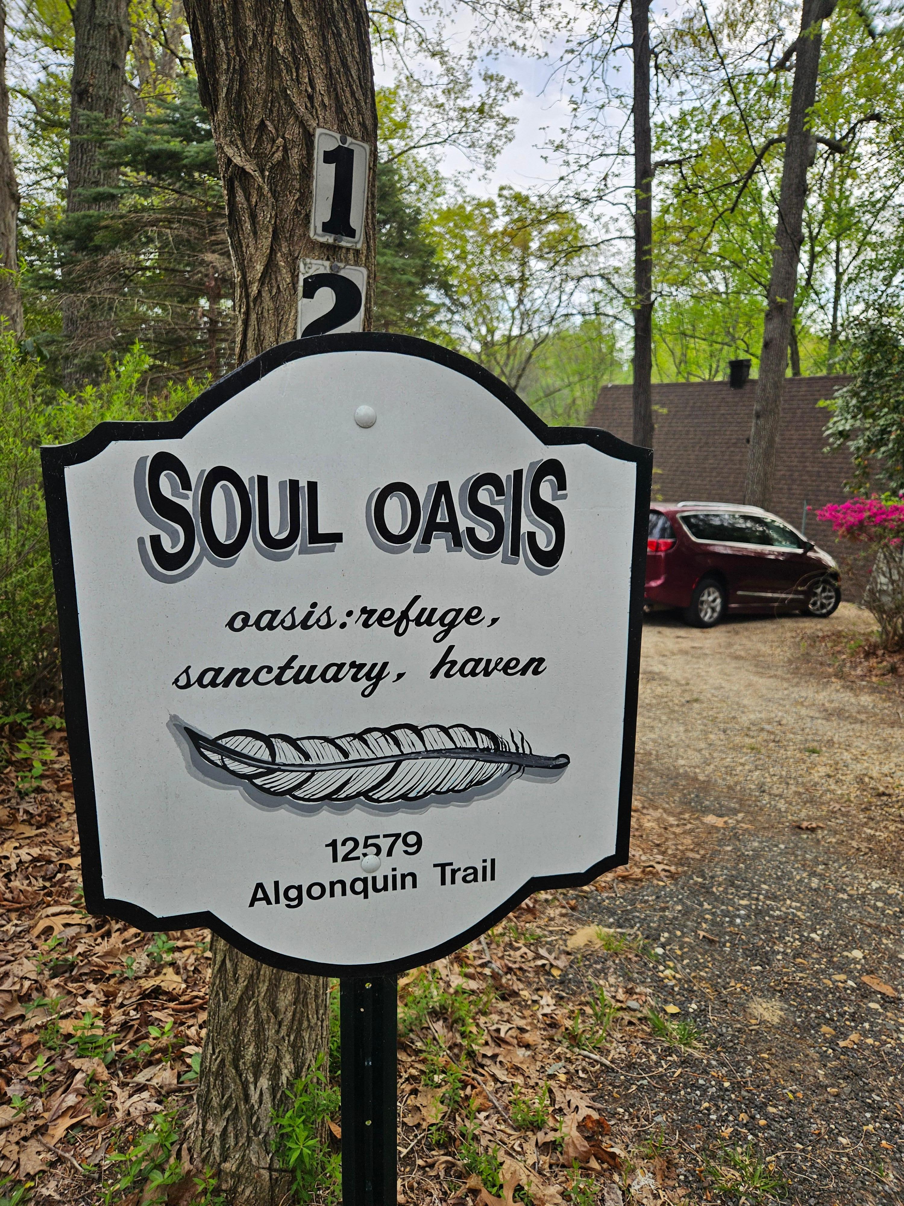 Welcome sign. Parking on the driveway flat spot, house roof behind.