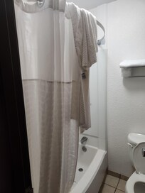 Dirty towel hanging from shower rod