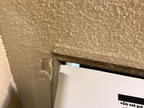 The air conditioning unit has pulled away from the wall and you can see outside.