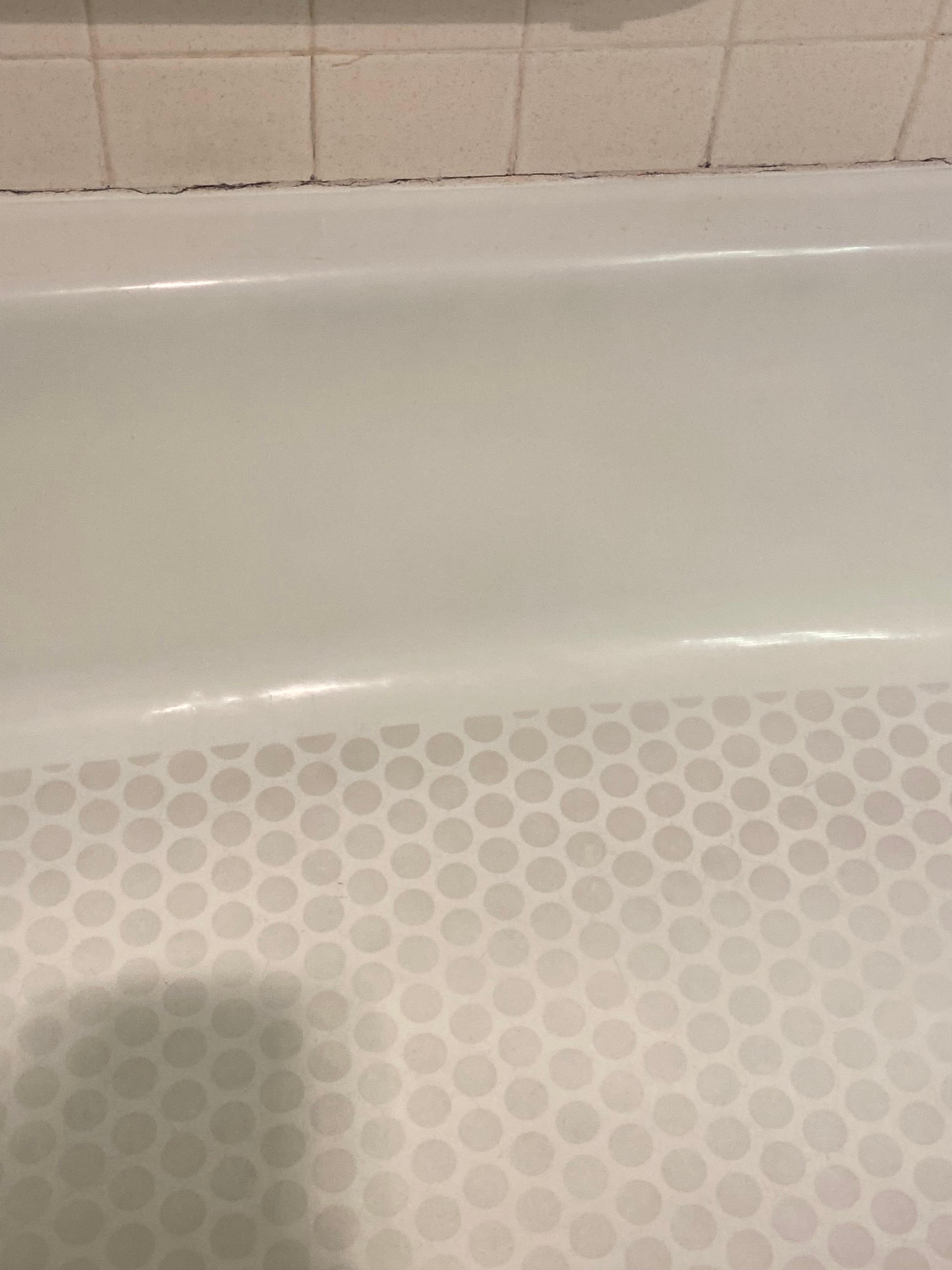 Filthy stained tub, missing caulking between tiles 