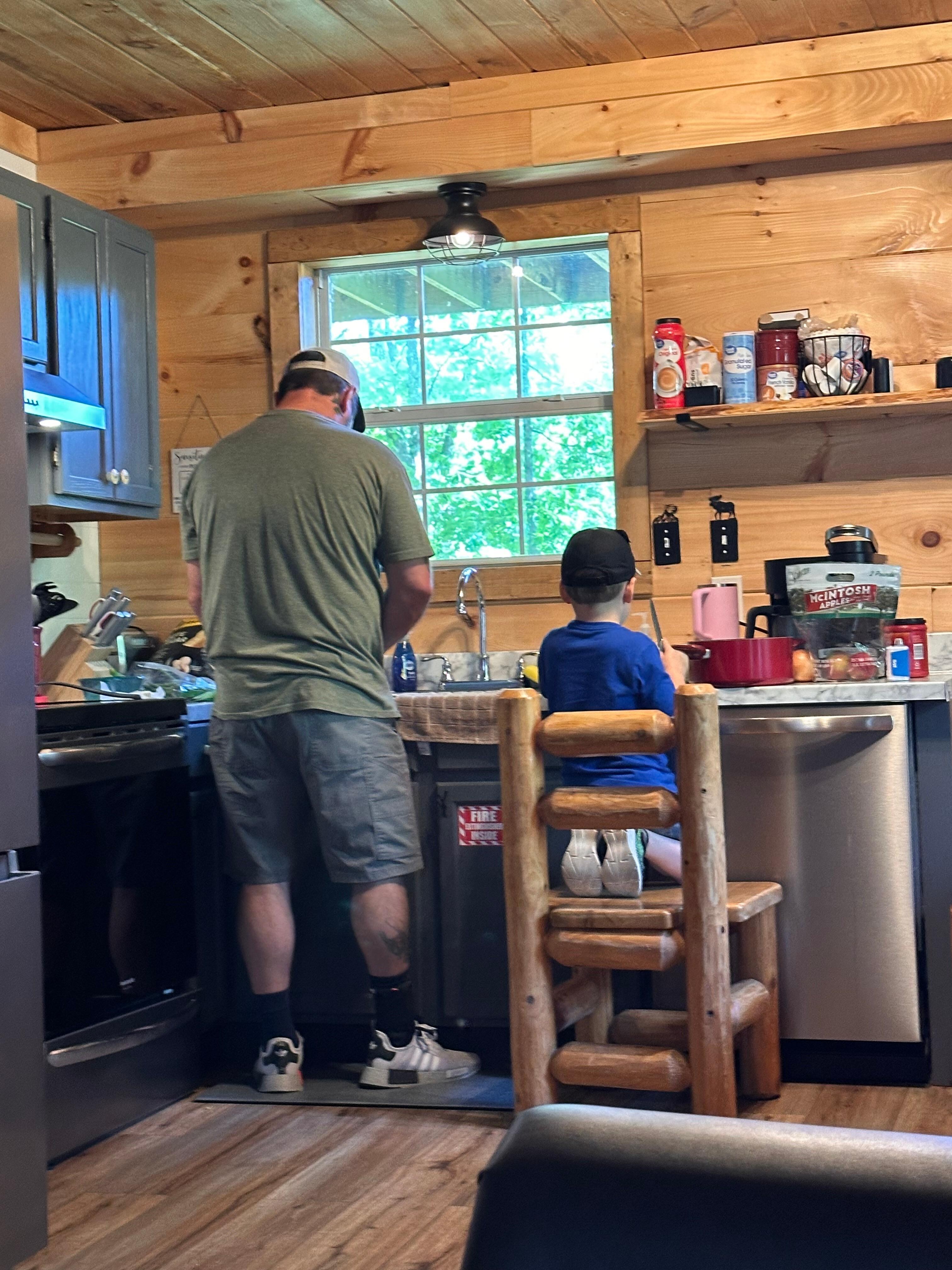 Dad and son cutting up in the kitchen 