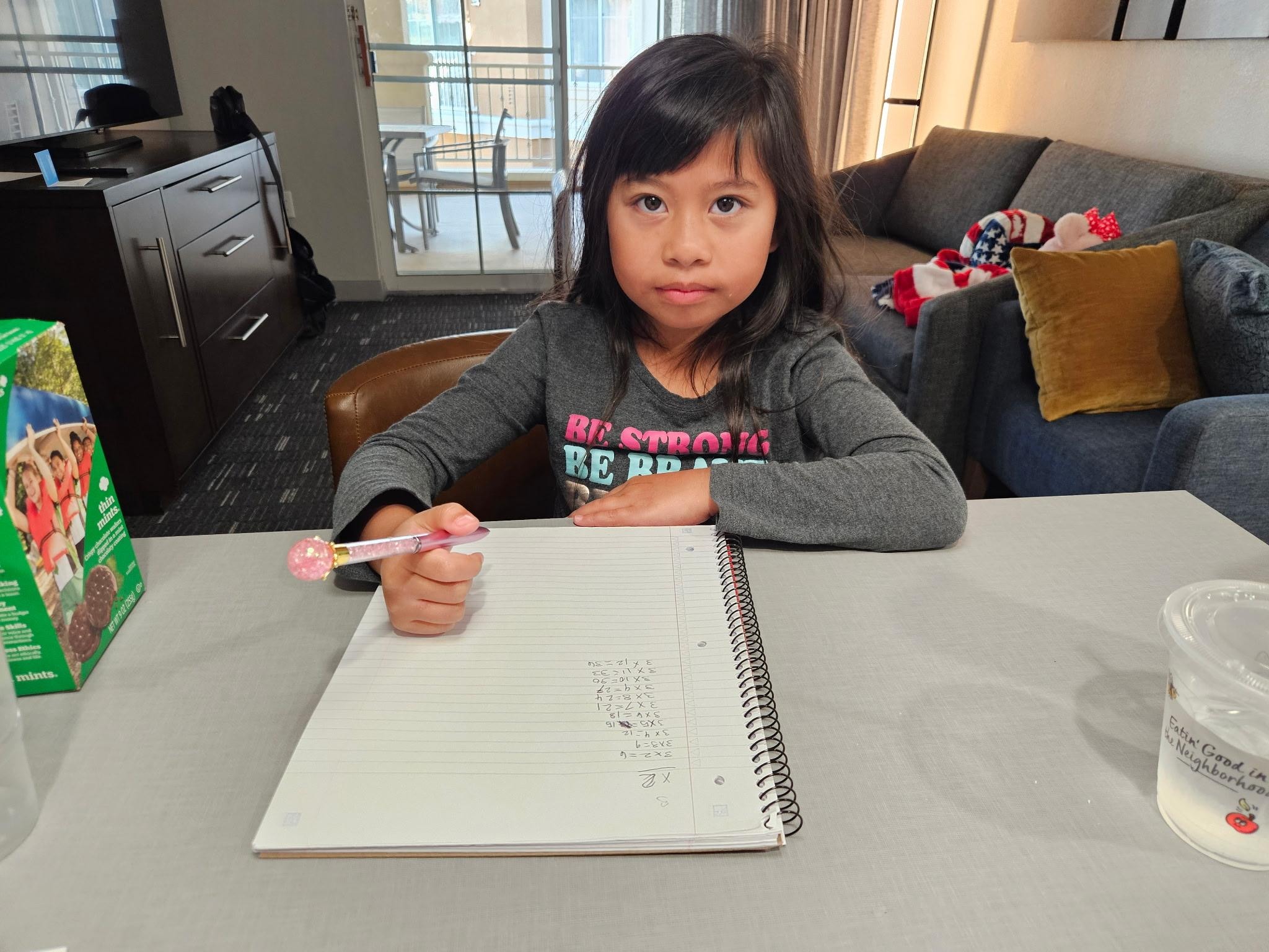 Dining table with living area behind and balcony. 