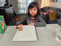 Dining table with living area behind and balcony.
