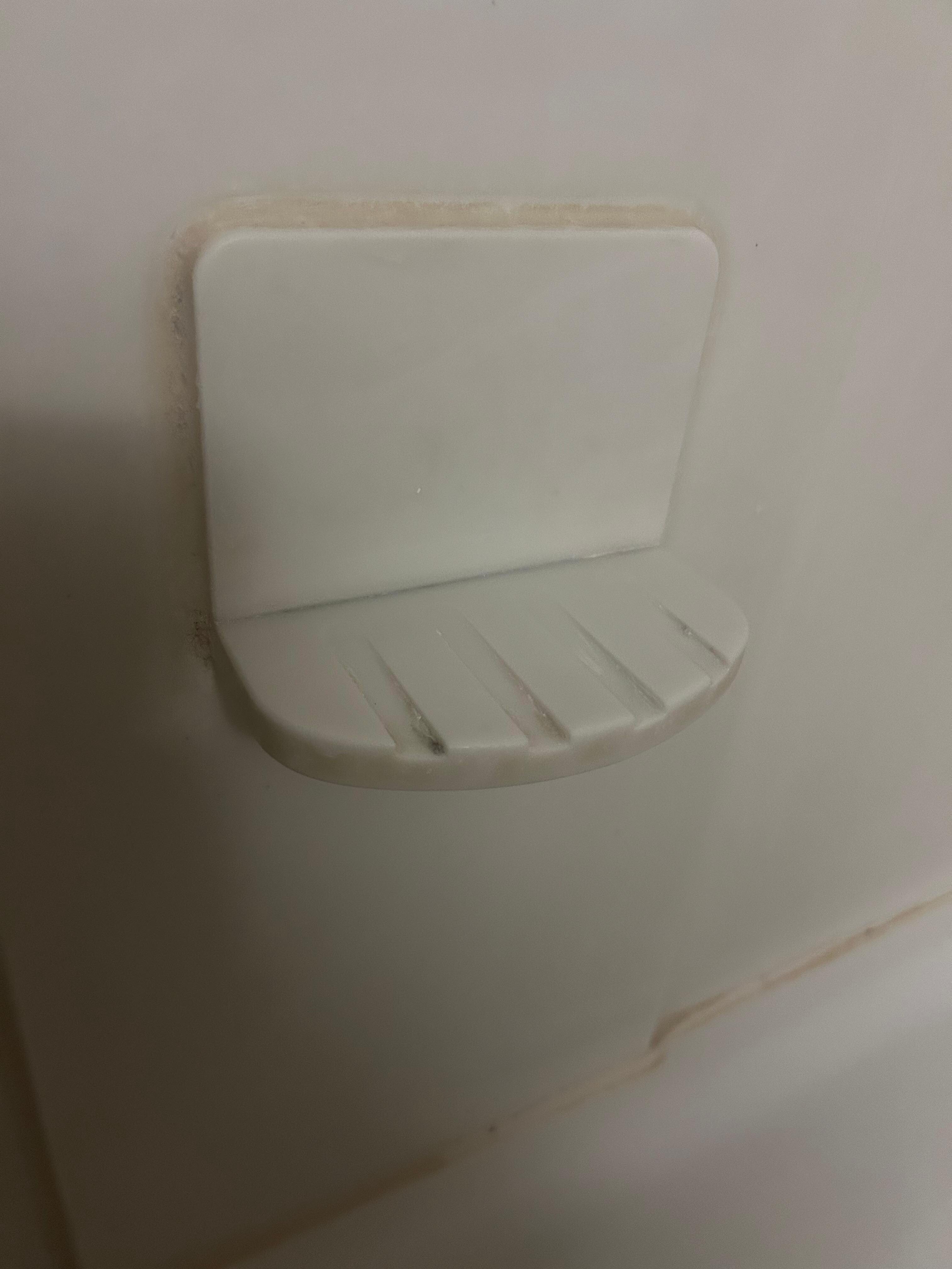 The shower wall and soap dish covered in grime and NOT clean!