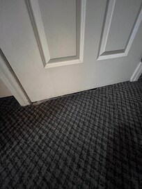 The main door to our room . The rug was pulling away from transition strip and was wet everywhere .