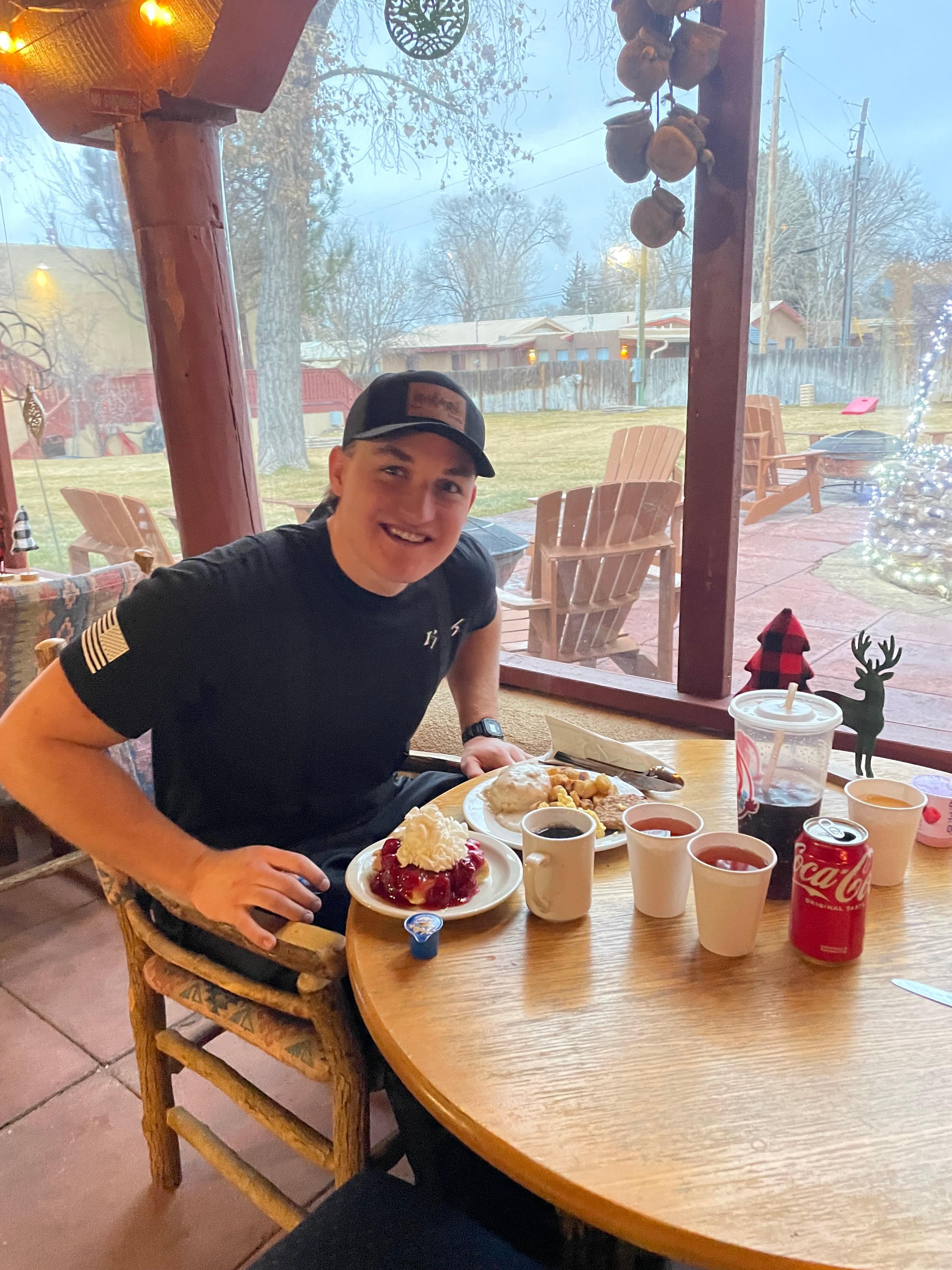 My son enjoying his favorite end of breakfast treat . The waffles with strawberries and cream . 