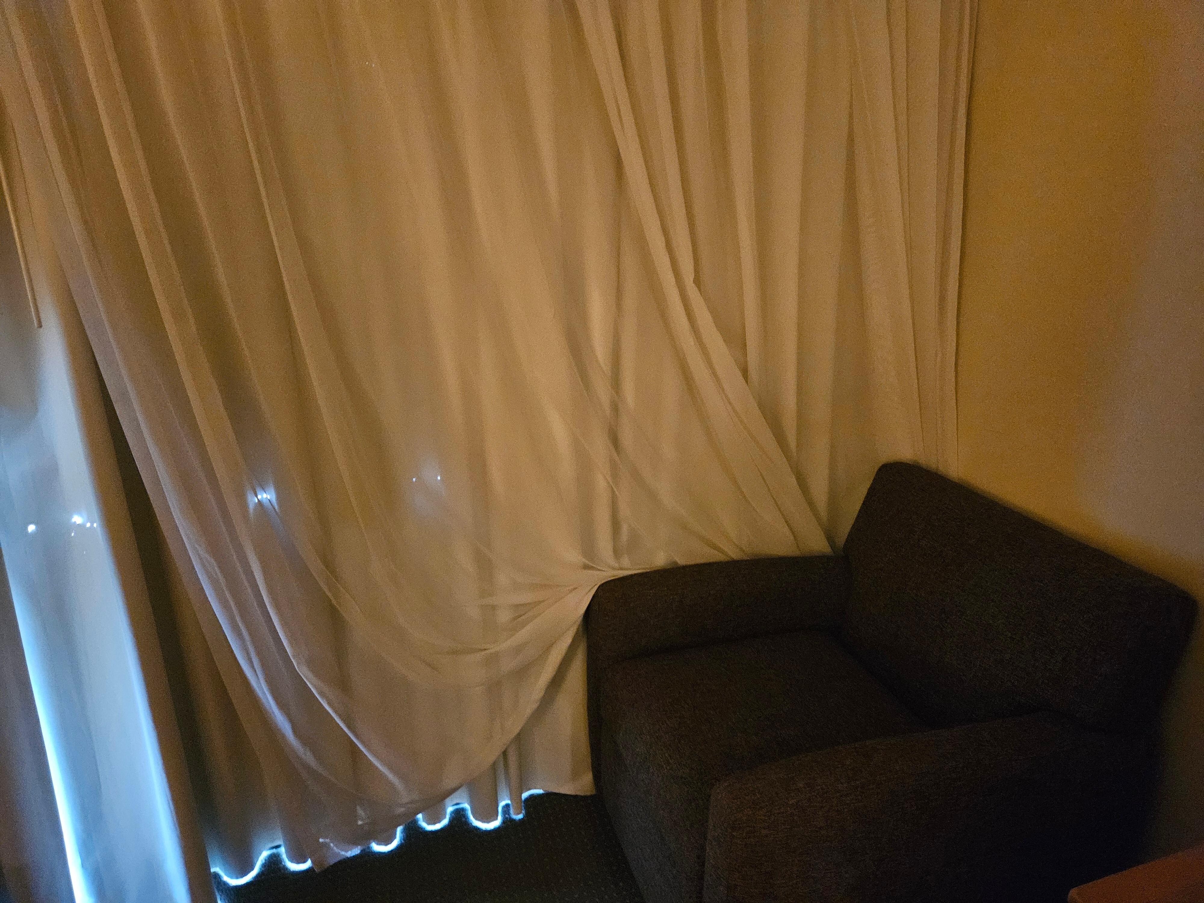 Curtains and chair placement on our entry to the room. The curtains had holes.