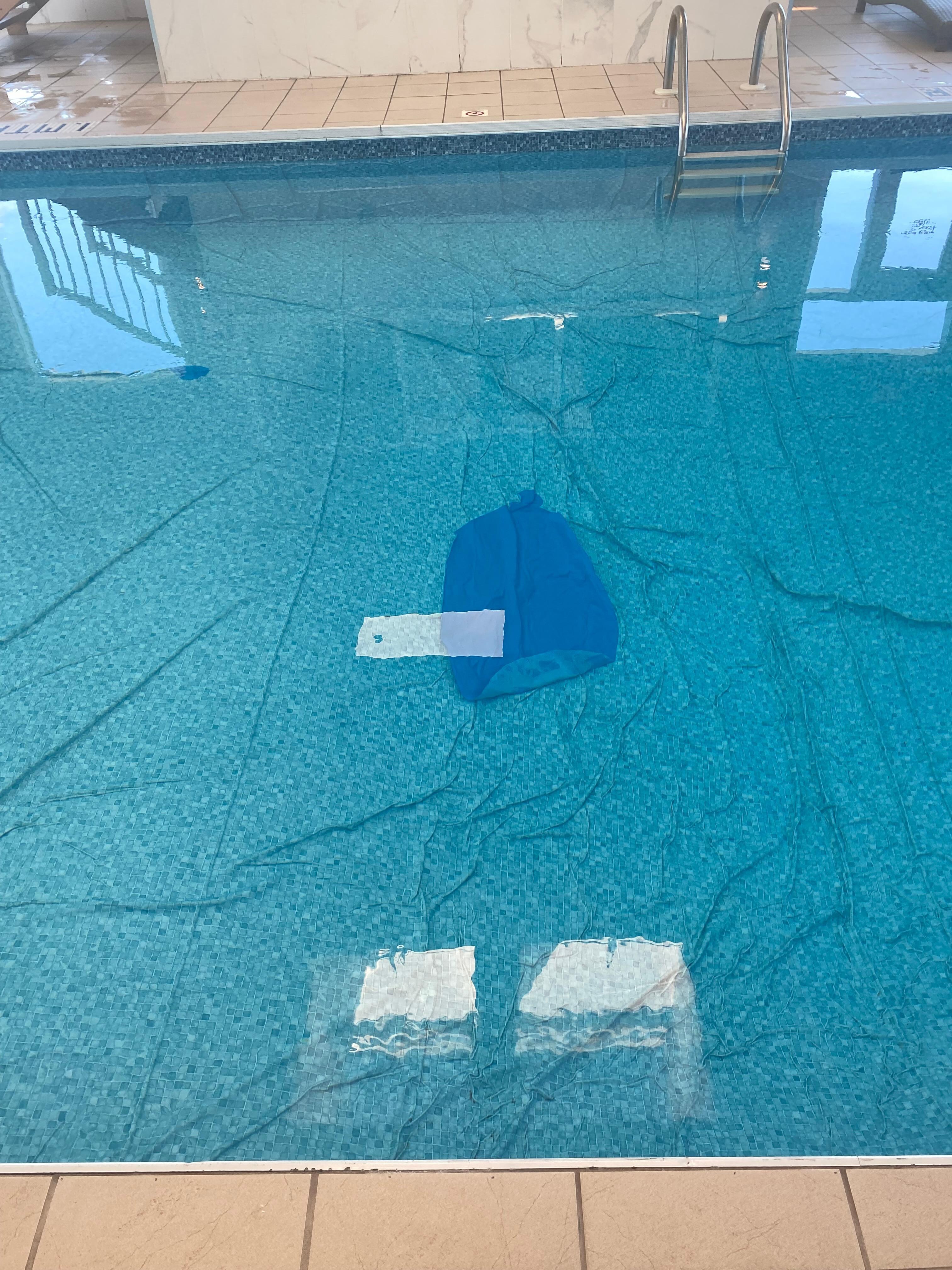 Pool liner is wrinkled and bunched up with a poorly done patch