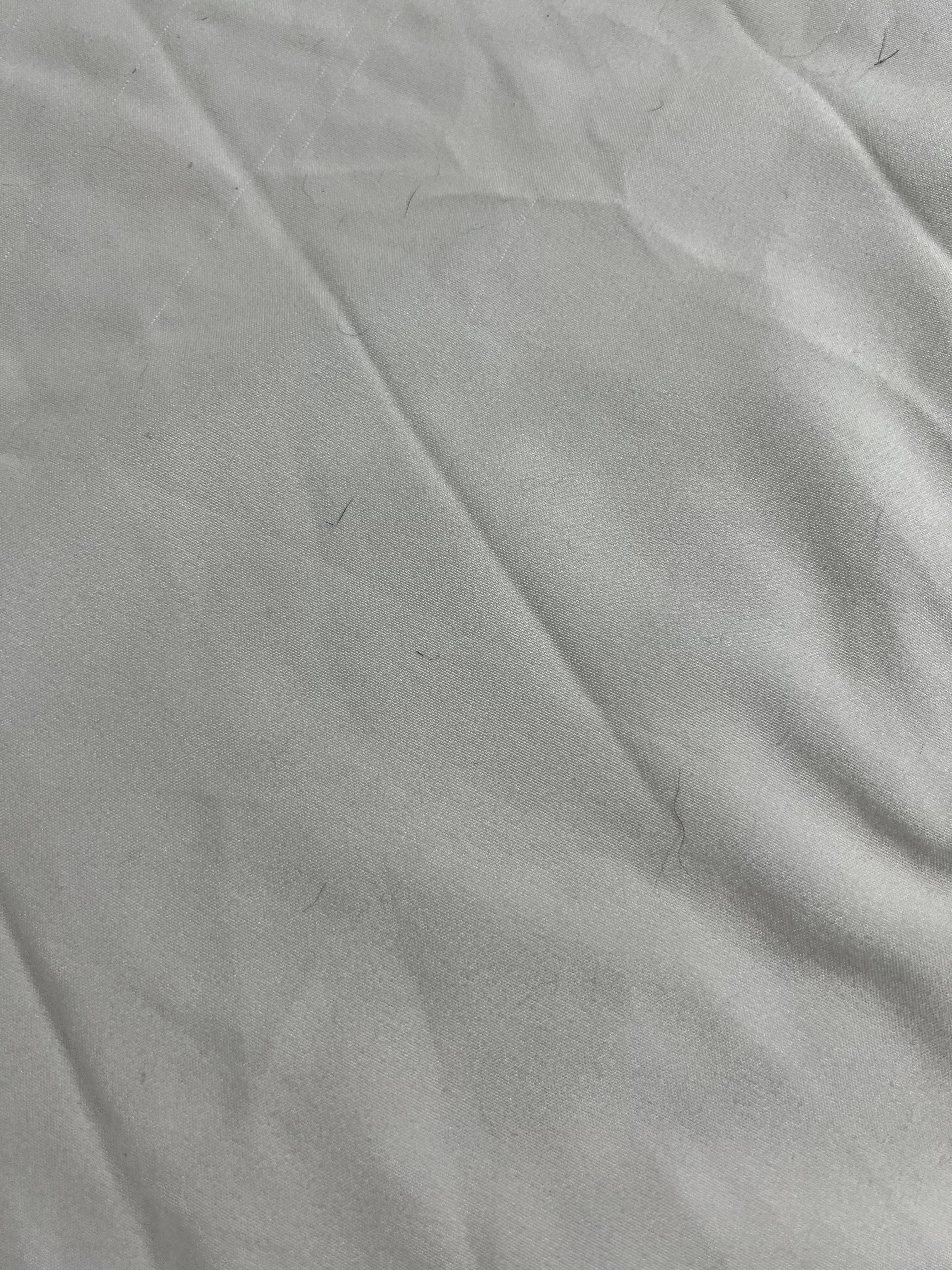 Sheets on bed covered with dog hair. 