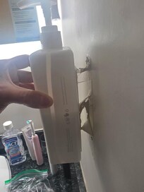 The lotion bottle that was being held on by peeling paint.