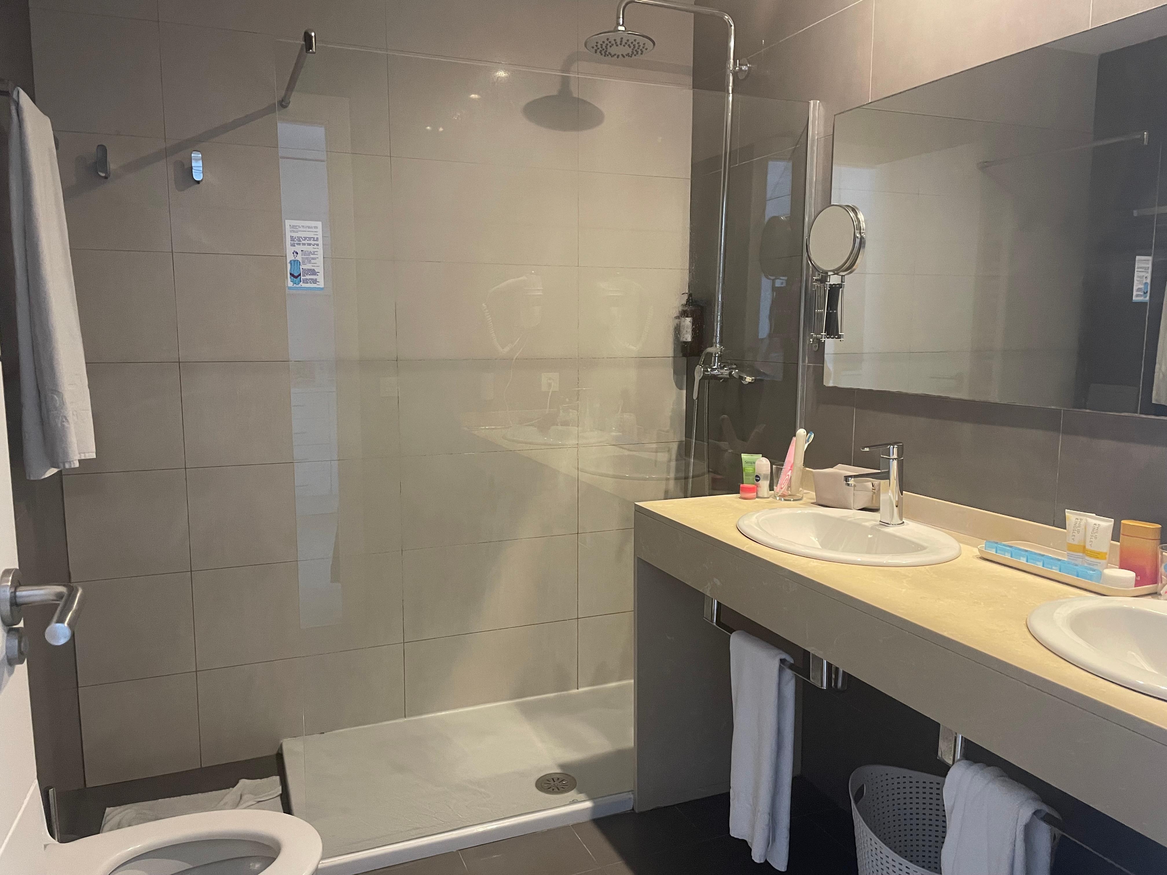 Spacious bathroom with a power shower and two sinks.