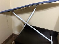 Broken ironing board hidden in the bathroom behind the door