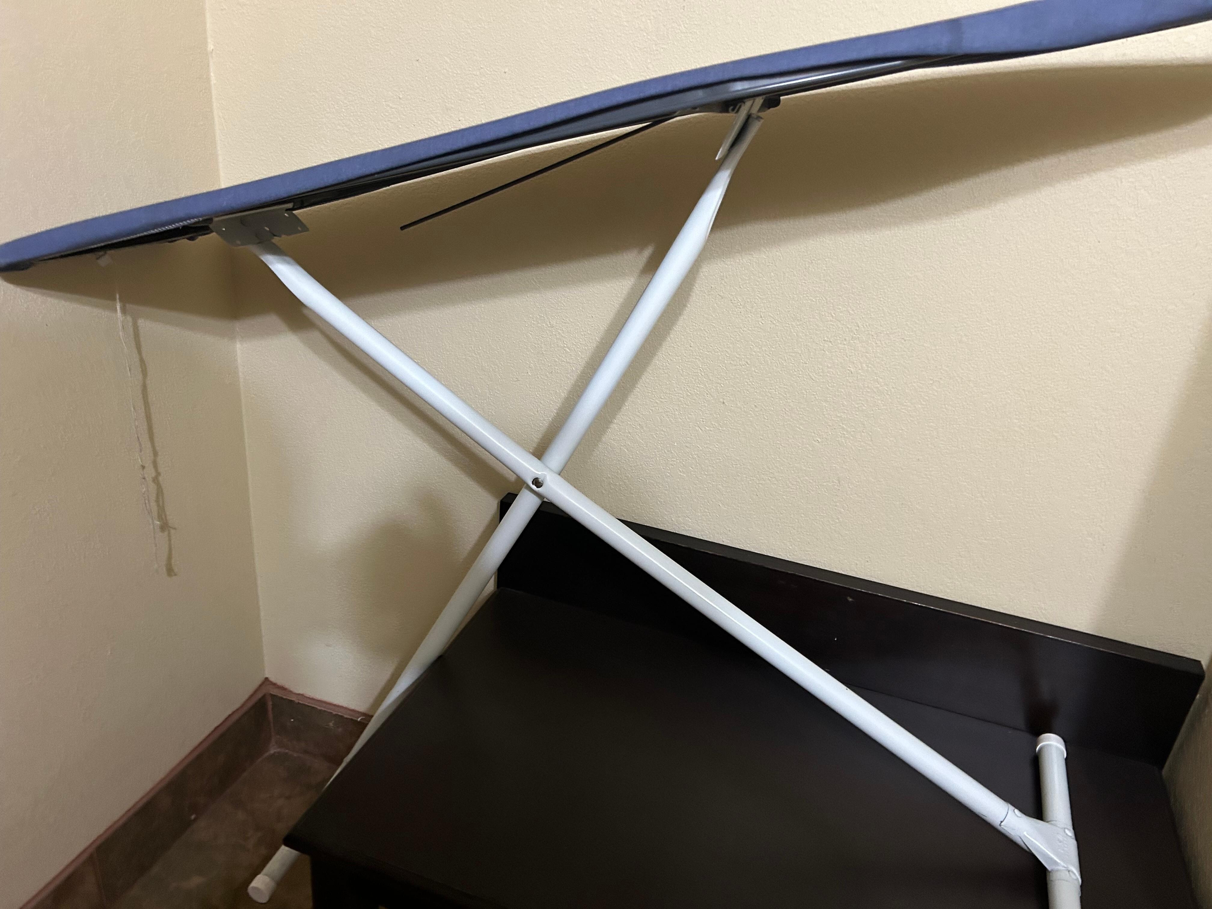 Broken ironing board hidden in the bathroom behind the door