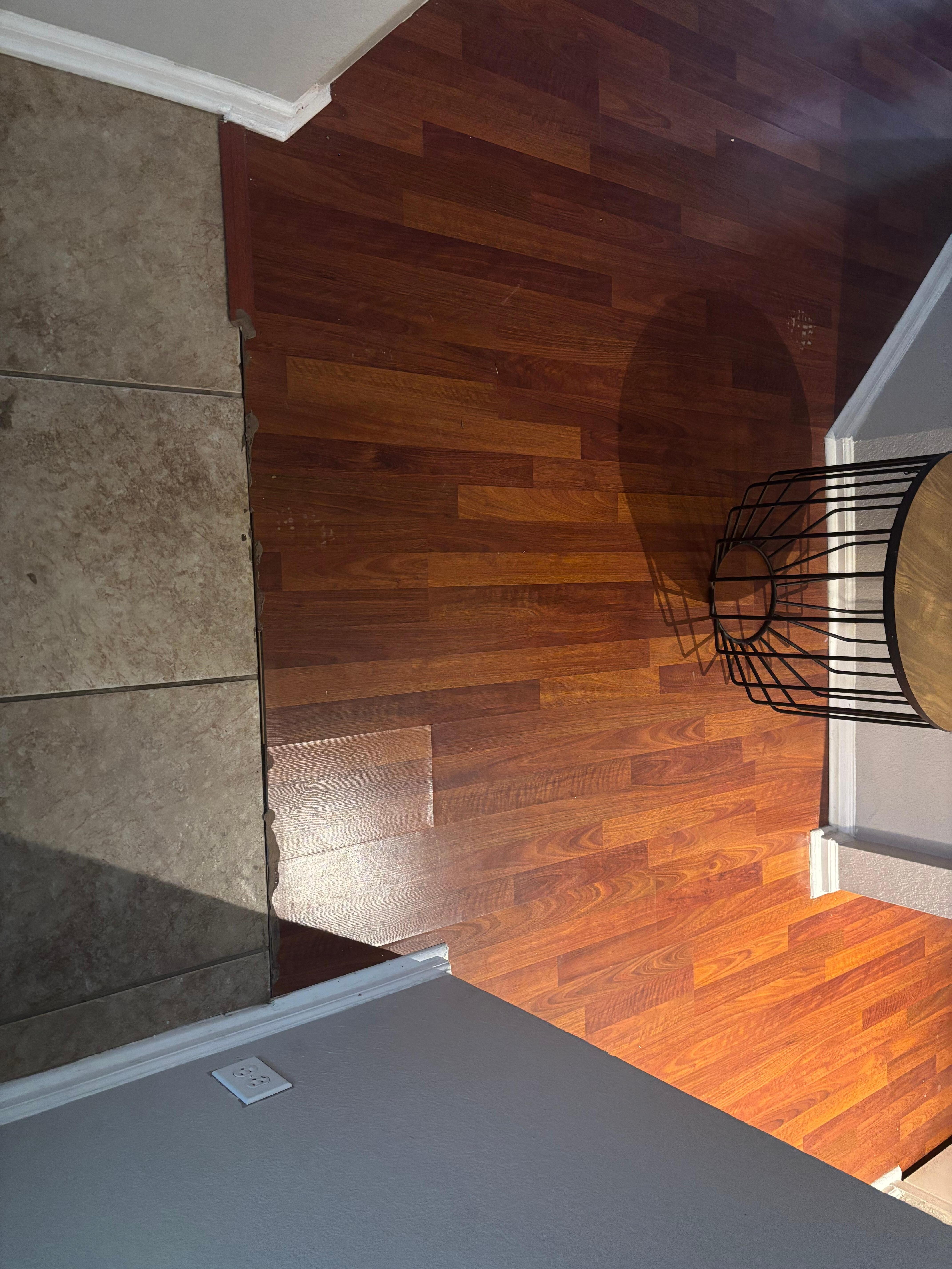 Water damage on flooring with broken transition strip. 