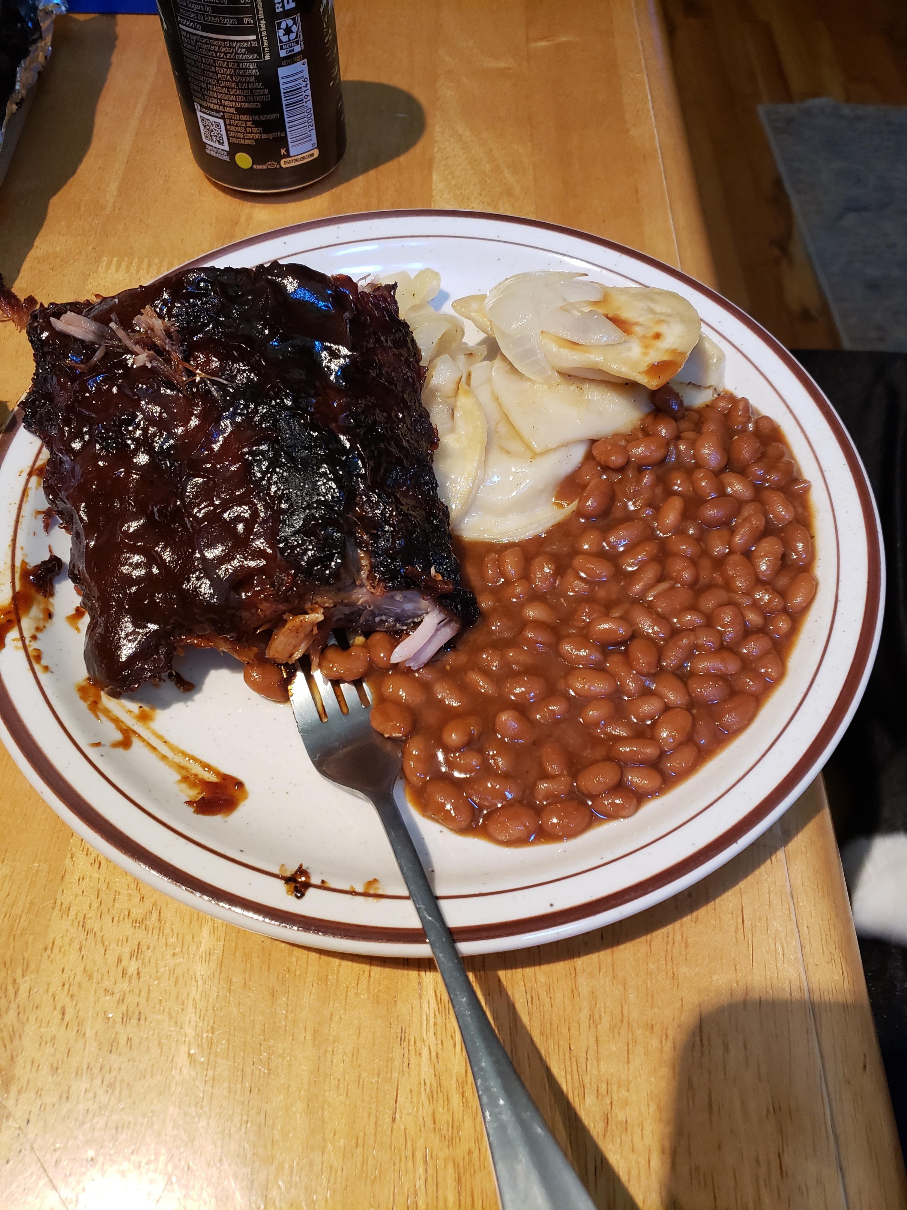 Bbq back ribs on the grill with progies and onions on the grill. Baked beans for our anniversary dinner.