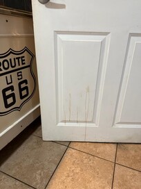 Something spilled on bathroom door, not cleaned up.