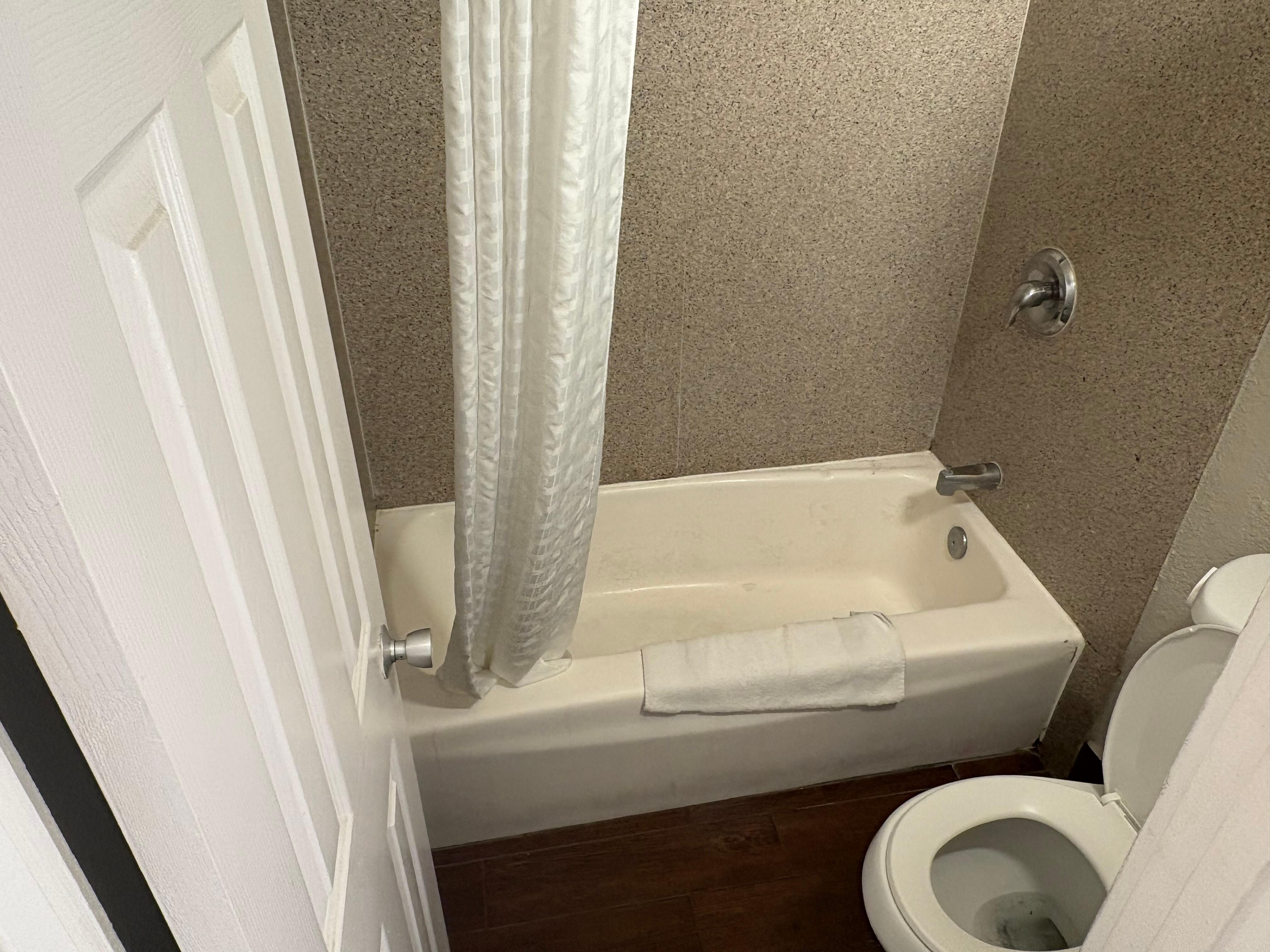 Stained toilet, bathtub and walls