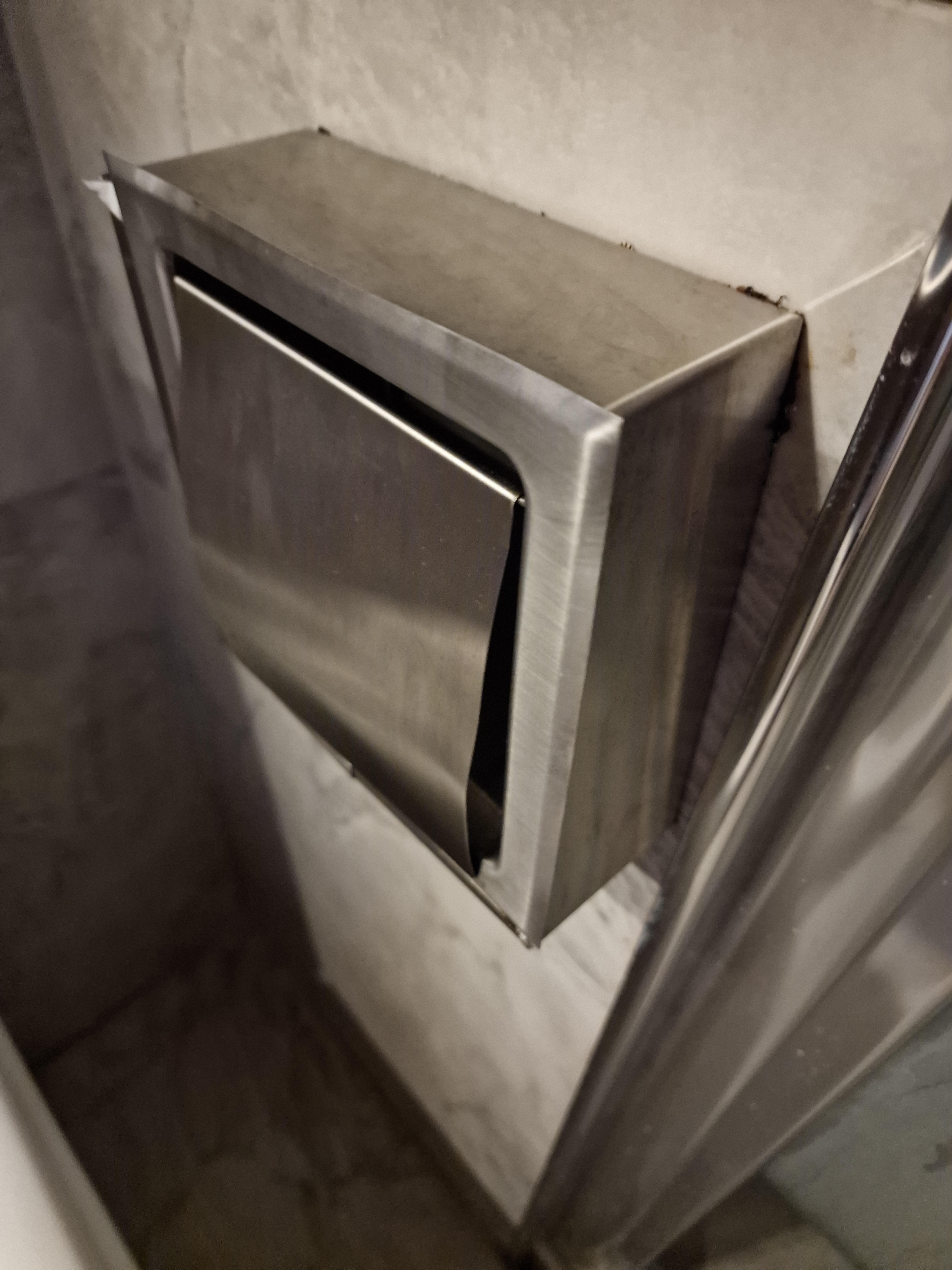 Next to your arm as you sit on the toilet, very sharp which i cut my arm on many times.