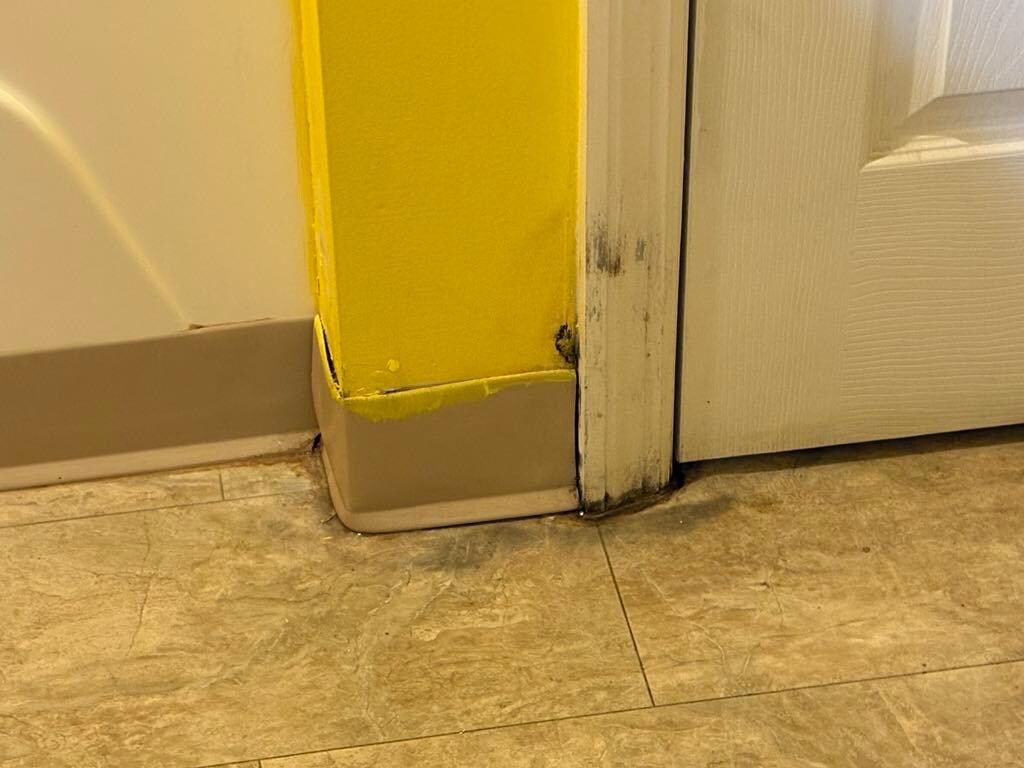 Water trickling out under locked door.