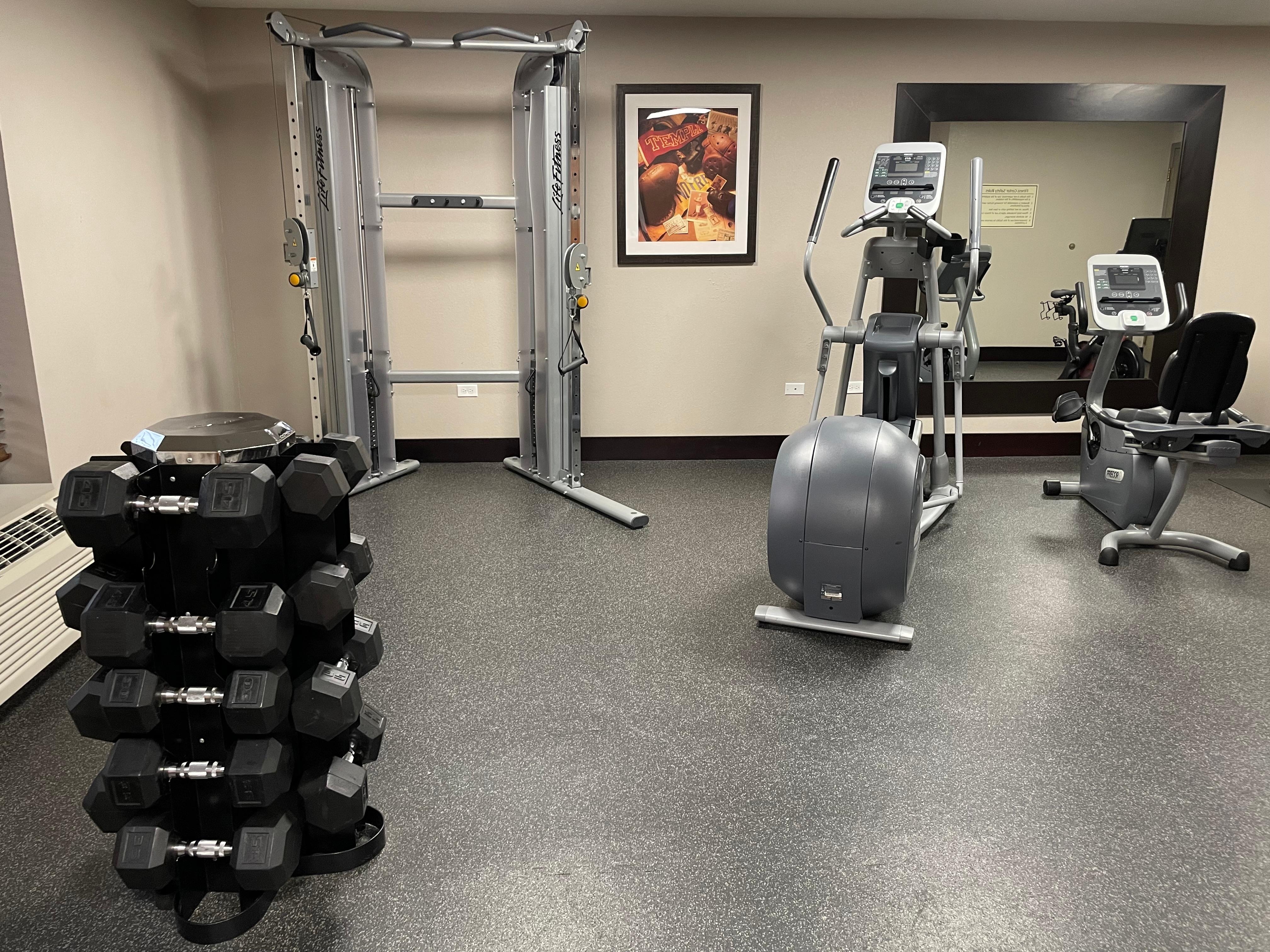 Fitness center with free-weights, cardio and a pulley machine. 