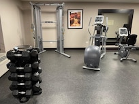 Fitness center with free-weights, cardio and a pulley machine.
