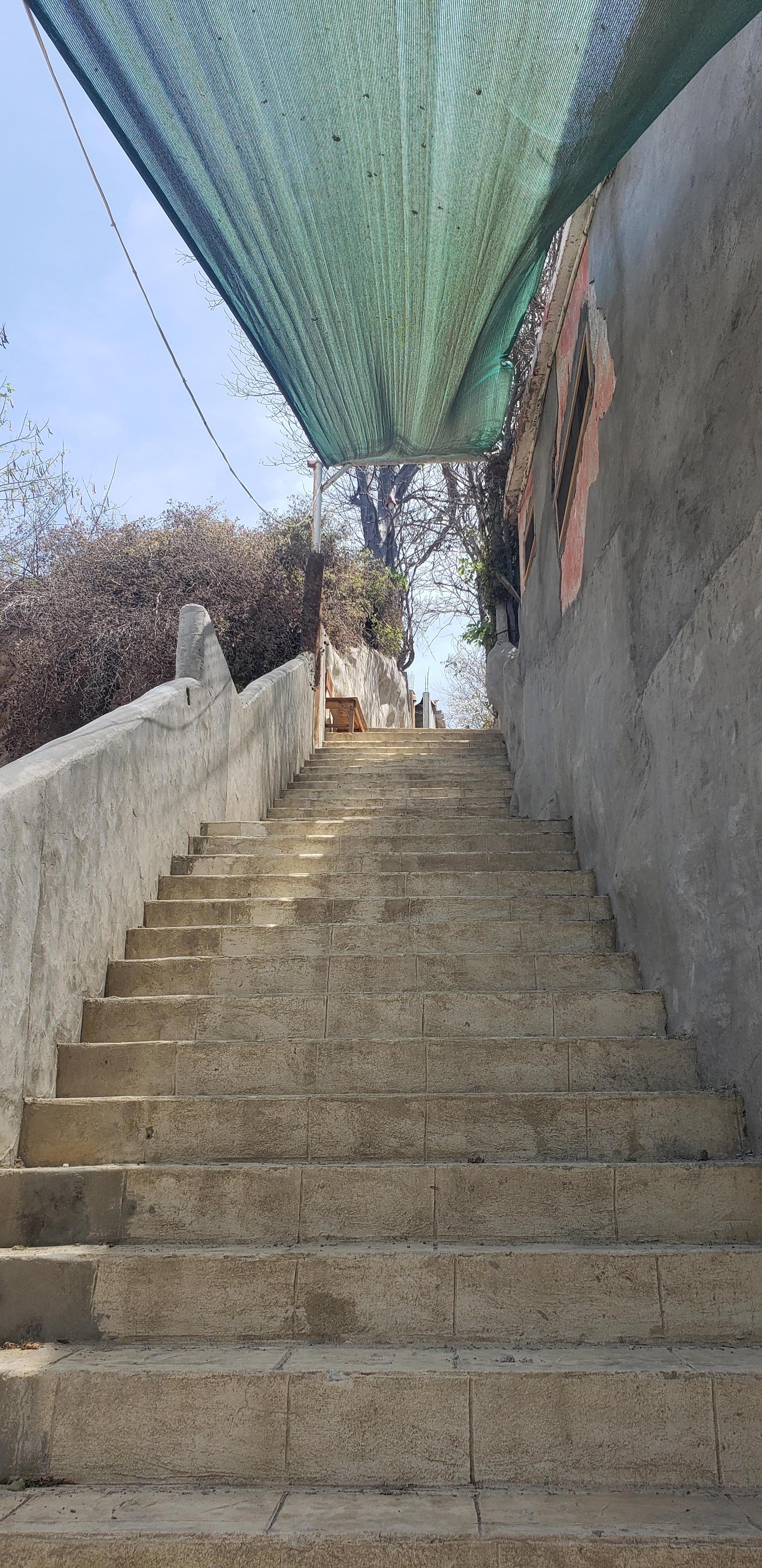 Solo se muestra la mitad de las escaleras, en la parte alta se ve una banca para hacer una pausa