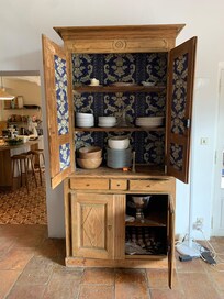Beautiful piece of furniture with plates and bowls just outside the kitchen