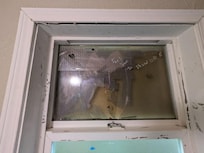 Broken window "secured" with cardboard and tape.