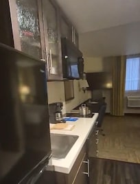 Cocina con refrigerador, horno de microondas, cafetera, utensilios de cocina